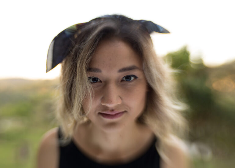 Foto do designer Denis Moribe sorrindo segurando uma caneta