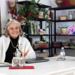 Retrato da psicóloga Solange Roumounoulou sentada em sua mesa no escritório